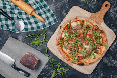 mouth-watering Neapolitan pizza on a blackboard with various delicious ingredients, free space for textの写真素材