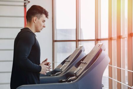 stylish guy in the gym is training on the treadmill. Healthy Lifestyle. wellness.の写真素材