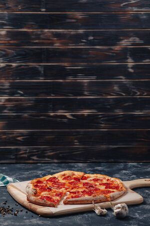 mouth-watering Neapolitan pizza on a blackboard with various delicious ingredients, free space for textの写真素材