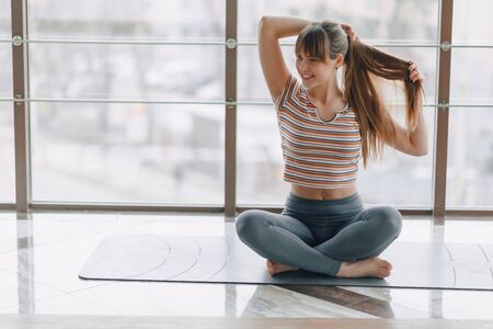 young attractive girl doing yoga, sports and healthy lifestyles, the concept of mental balanceの写真素材