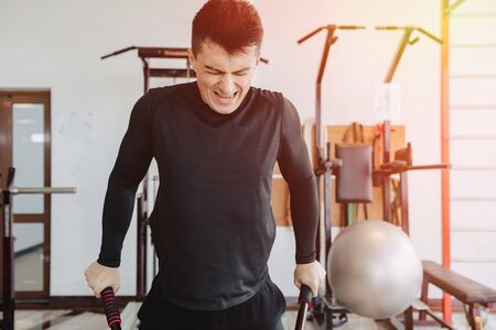 sports guy squeezes on bars, exercises on pectoral muscles. healthy lifestyle. wellness.の写真素材
