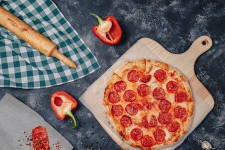 mouth-watering Neapolitan pizza on a blackboard with various delicious ingredients, free space for textの写真素材