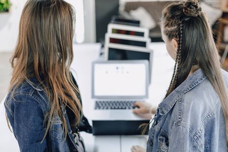 young attractive girls in an electronics store use a laptop at an exhibition. concept of buying gadgets and going to an electronics store.の写真素材