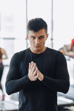 stylish guy in the gym rubs his hands with a talc. cloud of dust from hands. Healthy Lifestyle.の写真素材
