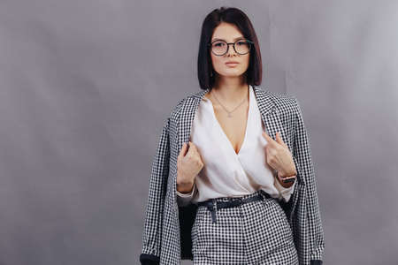Attractive young girl in stylish glasses in coat and yellow Beret on a simple light backgroundの写真素材