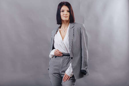 Attractive young girl in stylish glasses in coat and yellow Beret on a simple light backgroundの写真素材