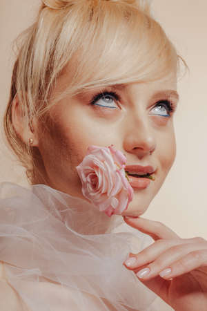 pretty attractive girl with blond hair, fashion shooting, rose, simple background, studioの写真素材