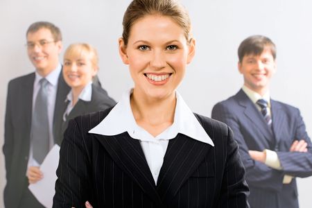 Portrait of attractive leader with her business team in the background