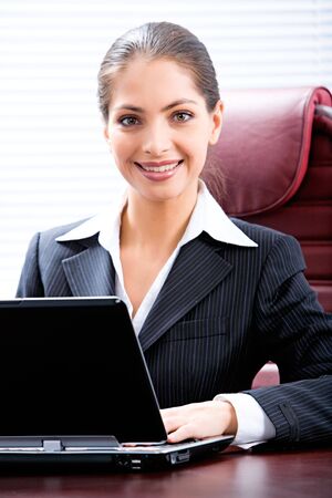 Portrait of attractive entrepreneur sitting at the table in the office 
