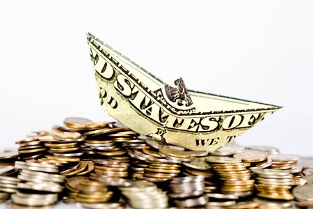 Image of ship made of dollar above a lot of coinsの写真素材