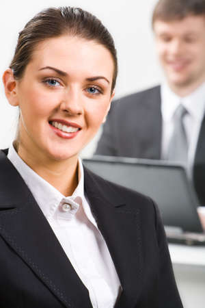 Portrait of confident woman in suit on the background of man の写真素材