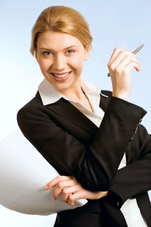Portrait of beautiful woman with pen and paper isolated on a blue backgroundの写真素材