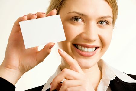 Image of pretty business woman holding a white business card pointing to it  の写真素材