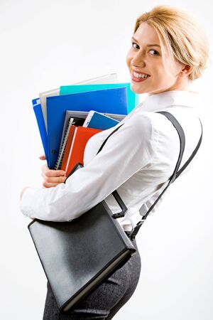 Portrait of a business woman with a pile of folders in her hand looking with smileの写真素材