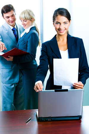 Portrait of business woman touching a paper, laptop and standing in the office  の写真素材