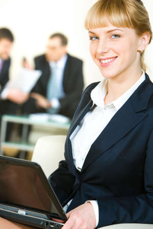 Portrait of cheerful specialist in suit holding the laptop の写真素材