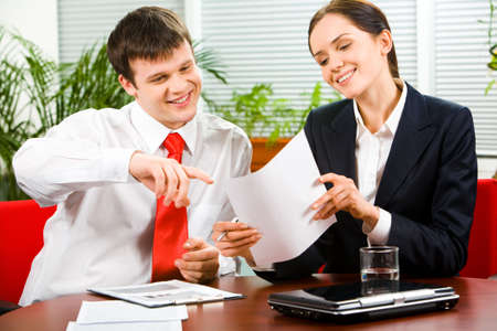 Portrait of business man explaining a new project  to attractive woman pointing at the document の写真素材