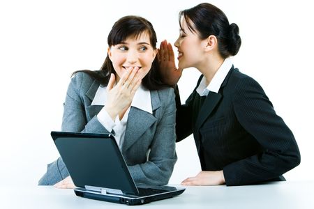 Image of business woman telling a secret to another 