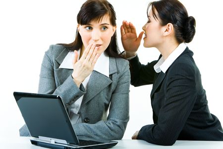 Portrait of business woman telling a secret to another one while at work