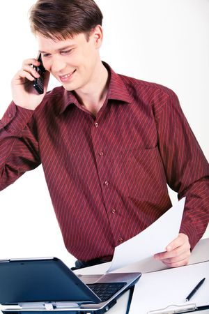 Photo of successful man speaking on the phone and looking at laptop monitor near byの写真素材