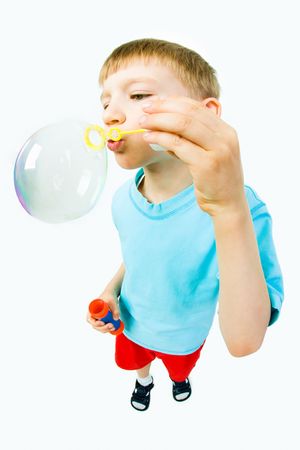 Portrait of cute child blowing soap bubbles isolated on white backgroundの写真素材