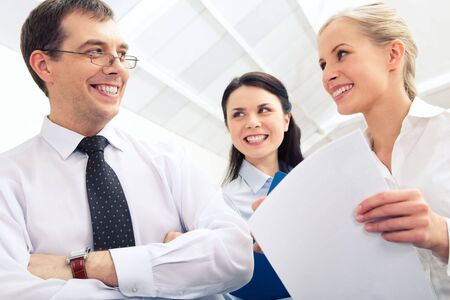 Photo of confident boss interacting with two businesswomen in the officeの写真素材
