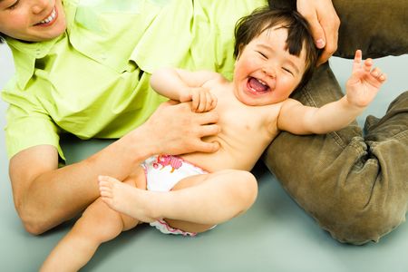Close-up of joyful child lying on the floor and laughing from ticklingの写真素材