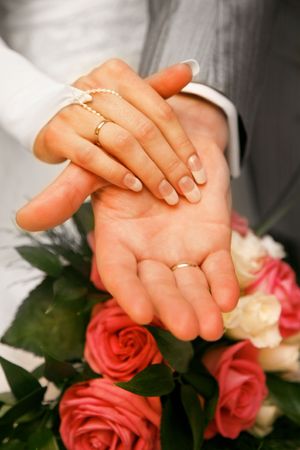 Photo of hands of newly-married over bunch of flowersの写真素材