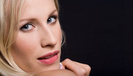 Close-up of blonde woman with seductive expression on her face looking at cameraの写真素材