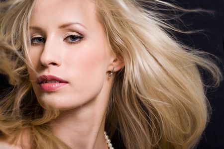 Portrait of beautiful young lady with blond hair looking at camera from asideの写真素材