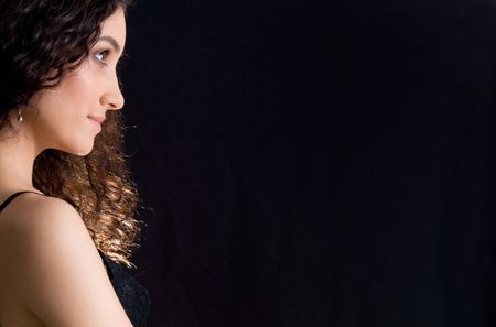 Profile of graceful brunette looking straight over black backgroundの写真素材