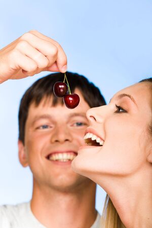 Photo of handsome man flirting with pretty woman on a blue background の写真素材