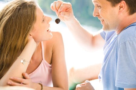 Image of man in t-shirt feeding the beautiful woman の写真素材