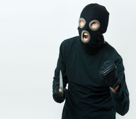 Portrait of felon in balaclava with knife in gloved handの写真素材