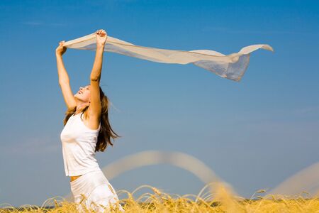 Portrait of laughing woman holding a silk cloth outdoor の写真素材