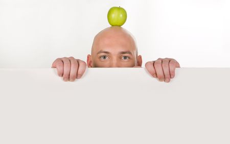 Upper part of bald mans face with apple on top behind white partitionの写真素材