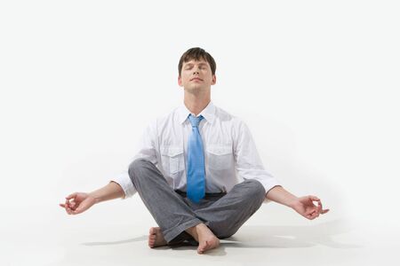 Photo of relaxed businessman meditating over white backgroundの写真素材