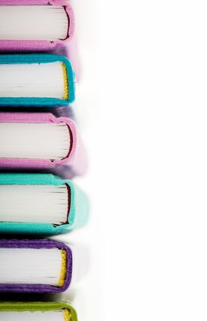 High pile of books or notepads in colorful covers over white backgroundの写真素材