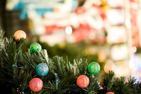 Close-up of colorful garland made up of small balls on Christmas tree branches