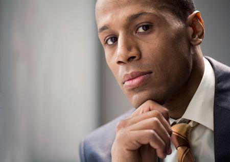 Portrait of confident entrepreneur keeping his hand on chin and looking at cameraの写真素材