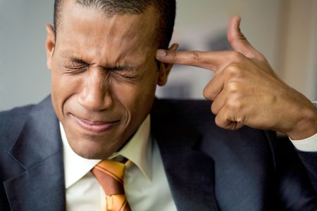 Image of confused man touching his temple with forefinger in troubleの写真素材