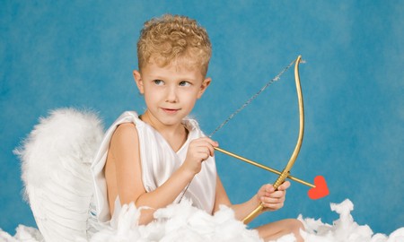 Portrait of little boy with bow and arrow ready to make someone fall in loveの写真素材