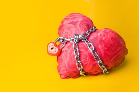 Creative image of soft toy heart bound with chain and small padlockの写真素材