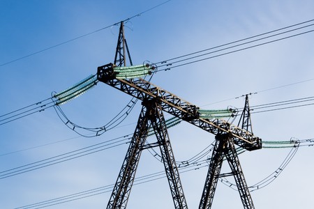 Image of nuclear power tower with wires in the background of blue sky