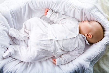Above view of fragile baby having a nod in comfortable cradle at home