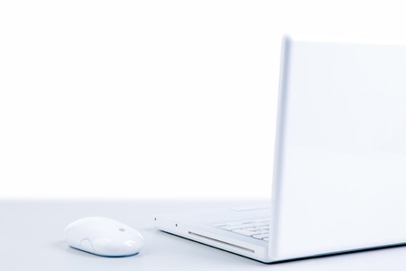 Photo of white cordless laptop with mouse of the same color near by
