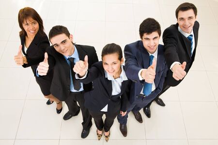 Above view of several successful partners looking at camera and showing thumbs up の写真素材