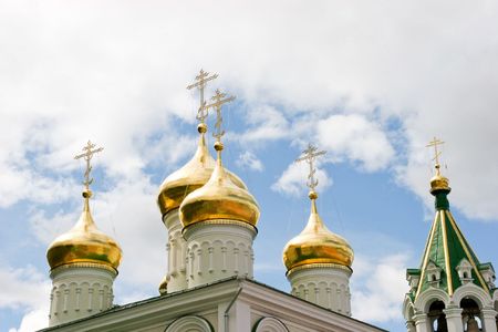 Several church domes with crosses on tops at background of cloudy sky