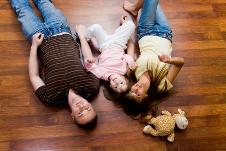 View from above of resting family lying on the floor and looking at cameraの写真素材