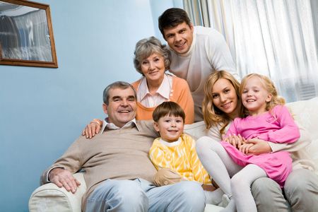 Portrait of senior and young couples with two children looking at camera at home